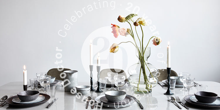 Table setting with rustic tableware and a green sculptural vase